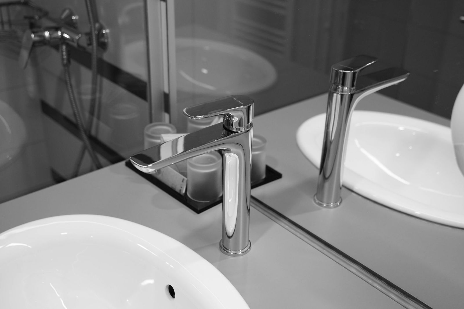 Newly fitted chrome taps over white bathroom basins