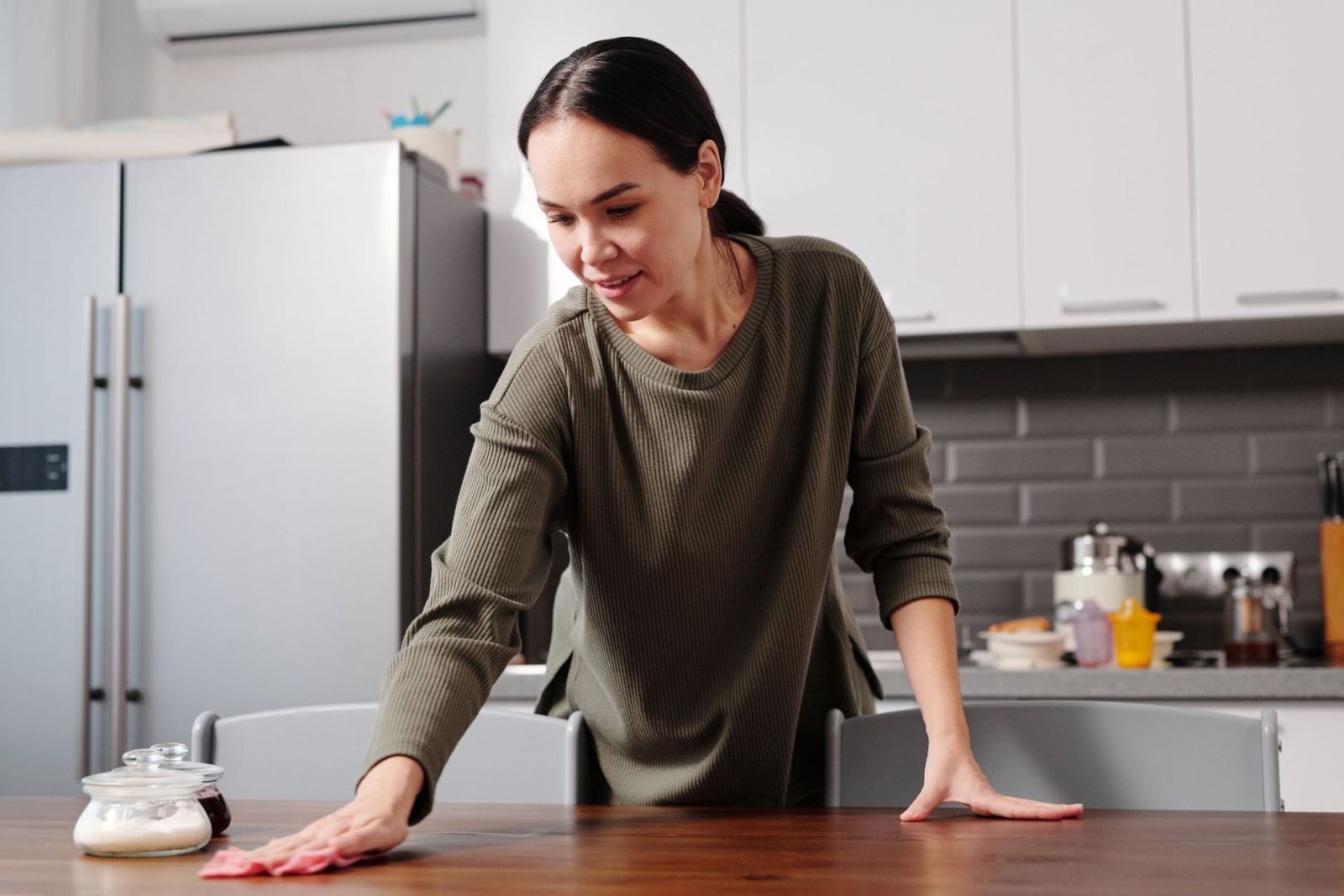 A cleaner wiping a kitchen table
